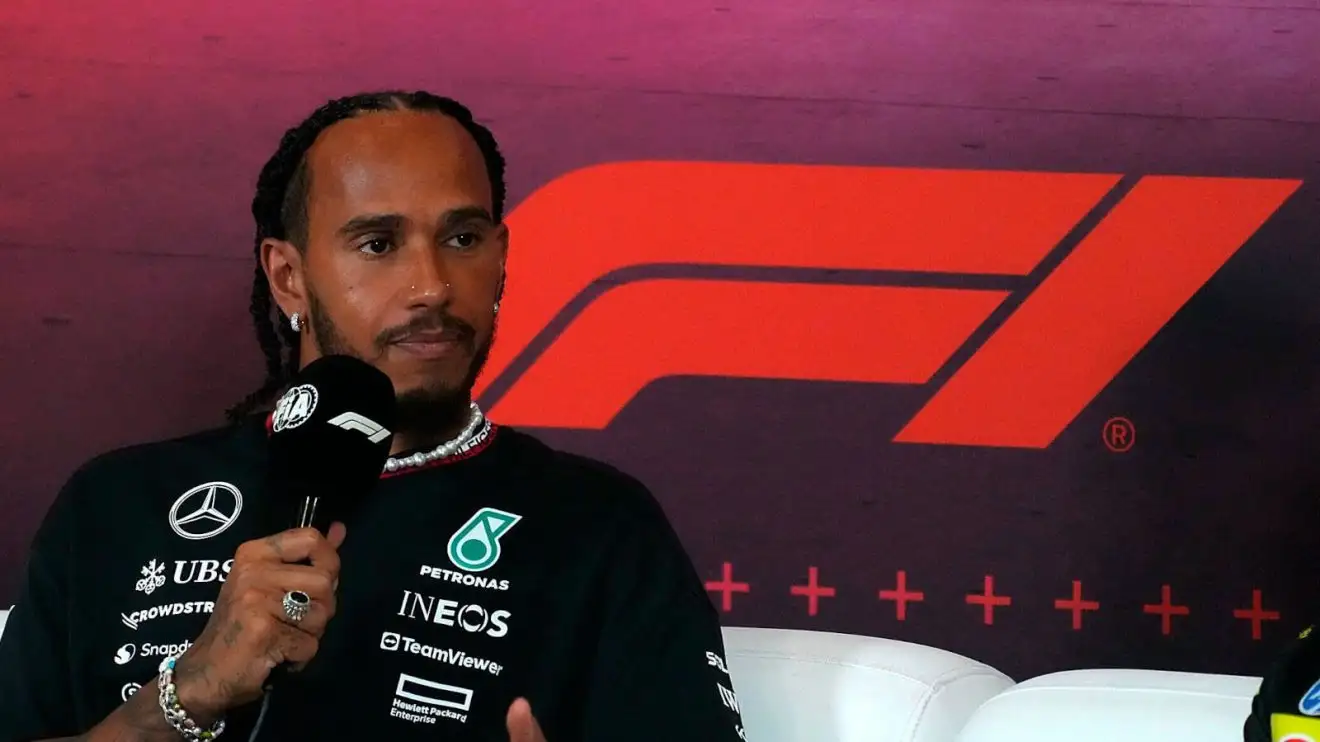 Lewis Hamilton in a press conference with the F1 logo behind him