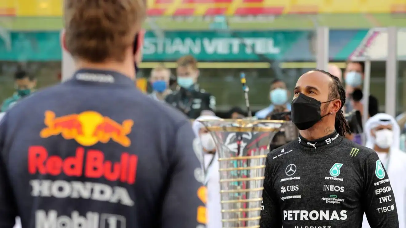 Max Verstappen and Lewis Hamilton either side of the Drivers' Championship trophy ahead of their Abu Dhabi 2021 title decider