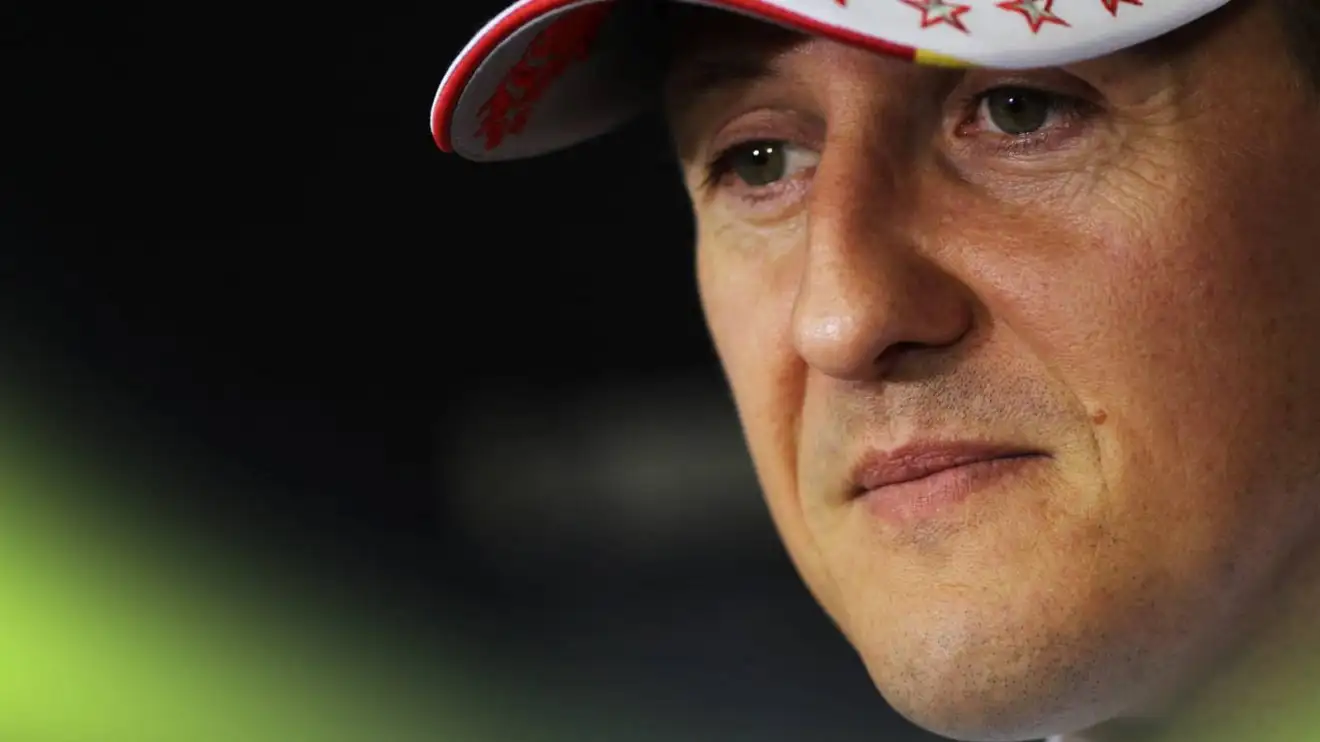 A close-up shot of Michael Schumacher looking on in a press conference