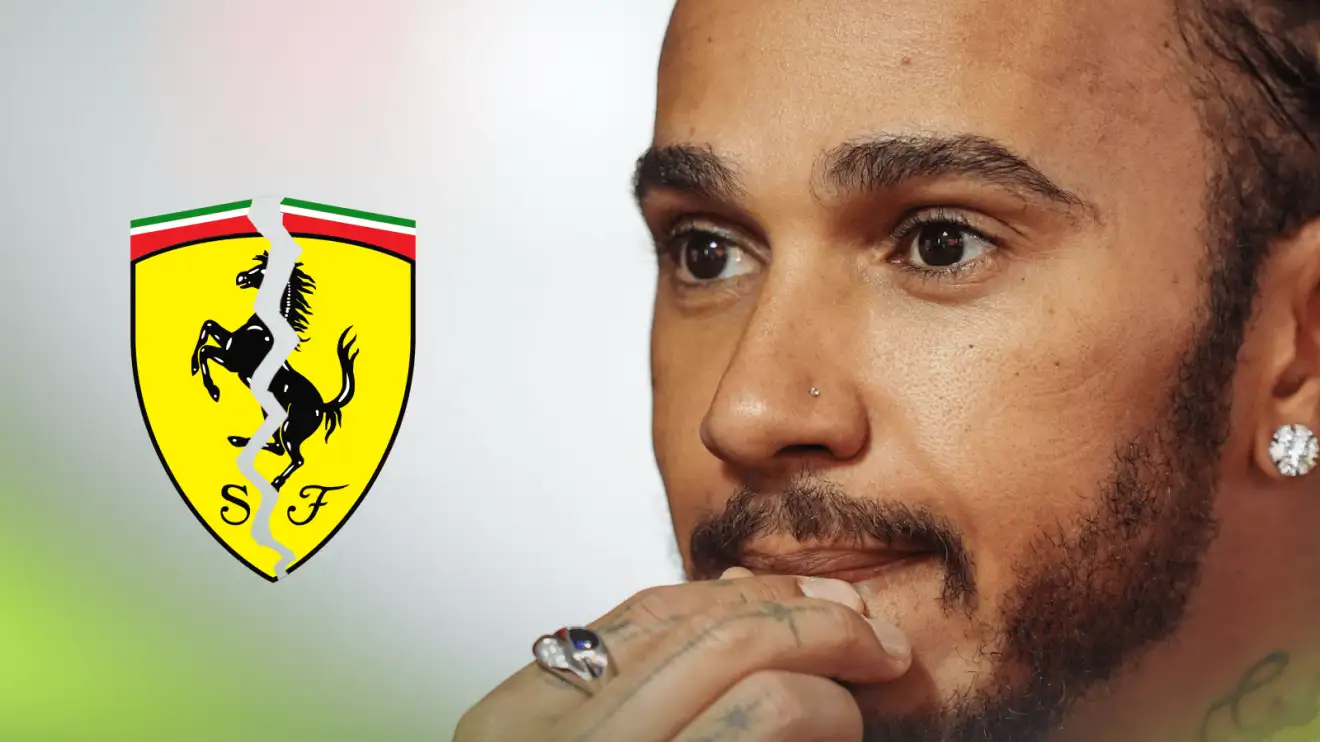 Lewis Hamilton holds his hand to his lips in concern with a cracked Ferrari badge alongside him