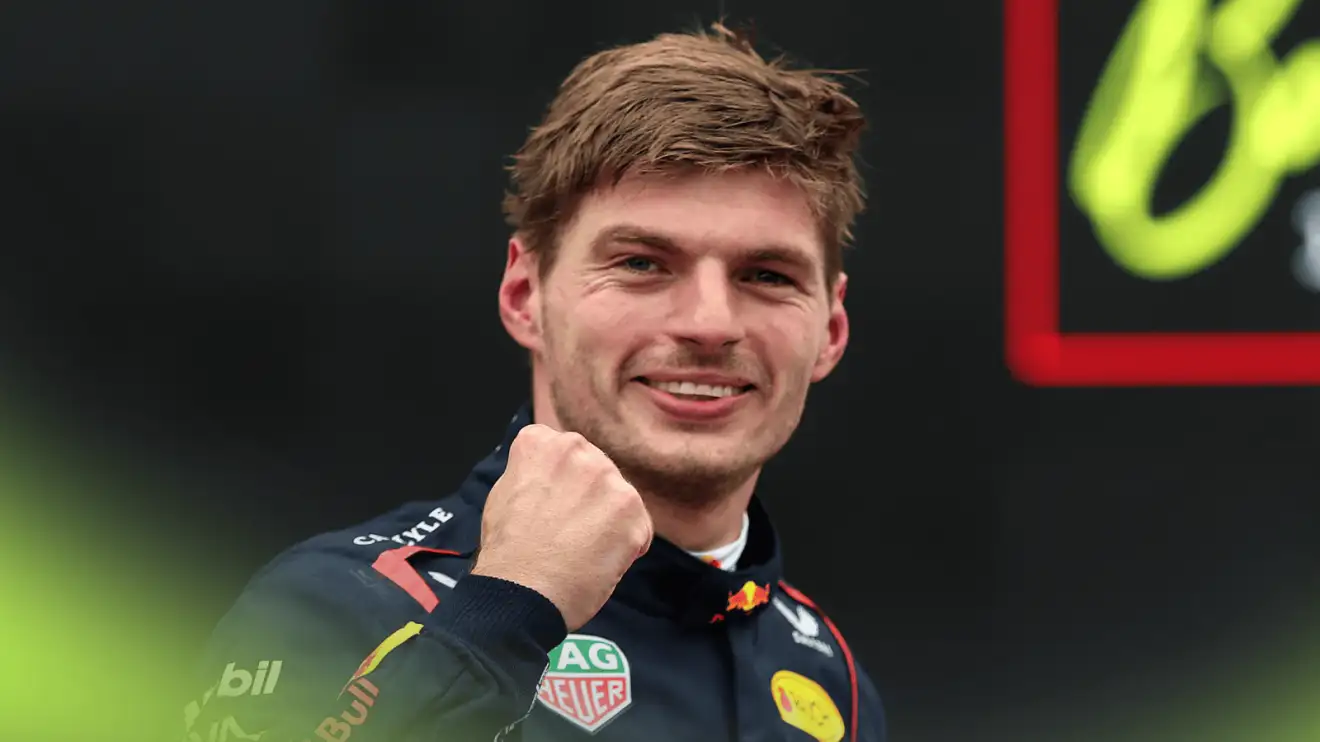 Max Verstappen smiles and punches the air as he eyes the camera in parc ferme