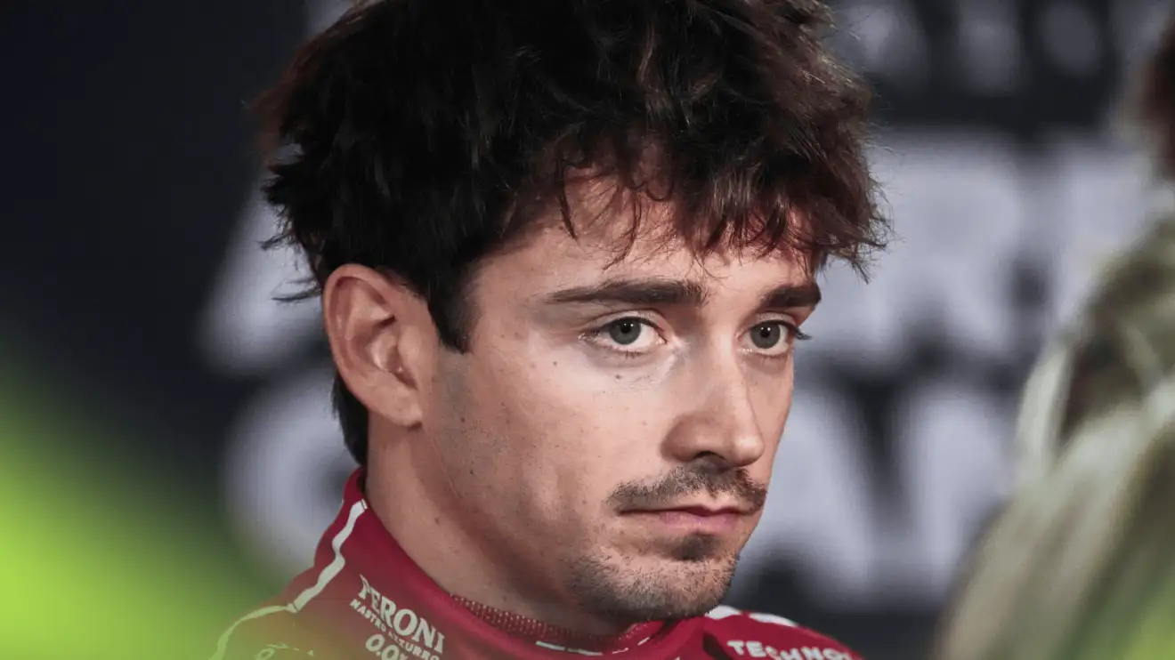 Charles Leclerc frowns as he faces the media