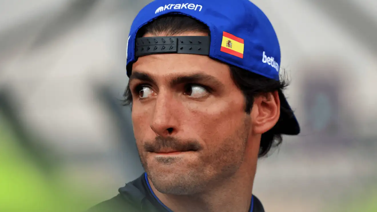 Carlos Sainz glances to the side in the Singapore GP paddock while wearing his cap back to front