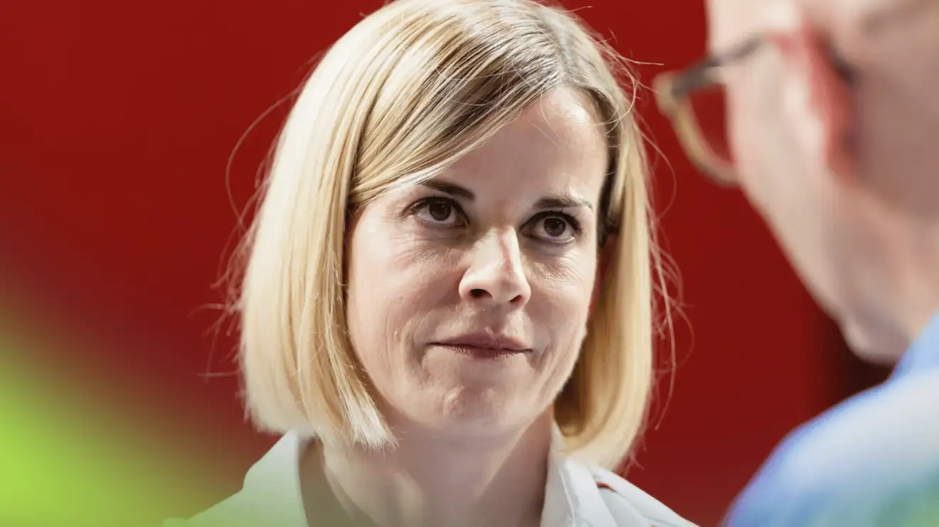 A close-up shot of Susie Wolff in conversation in the F1 paddock