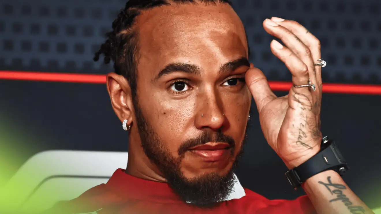 Lewis Hamilton touches his face in a press conference