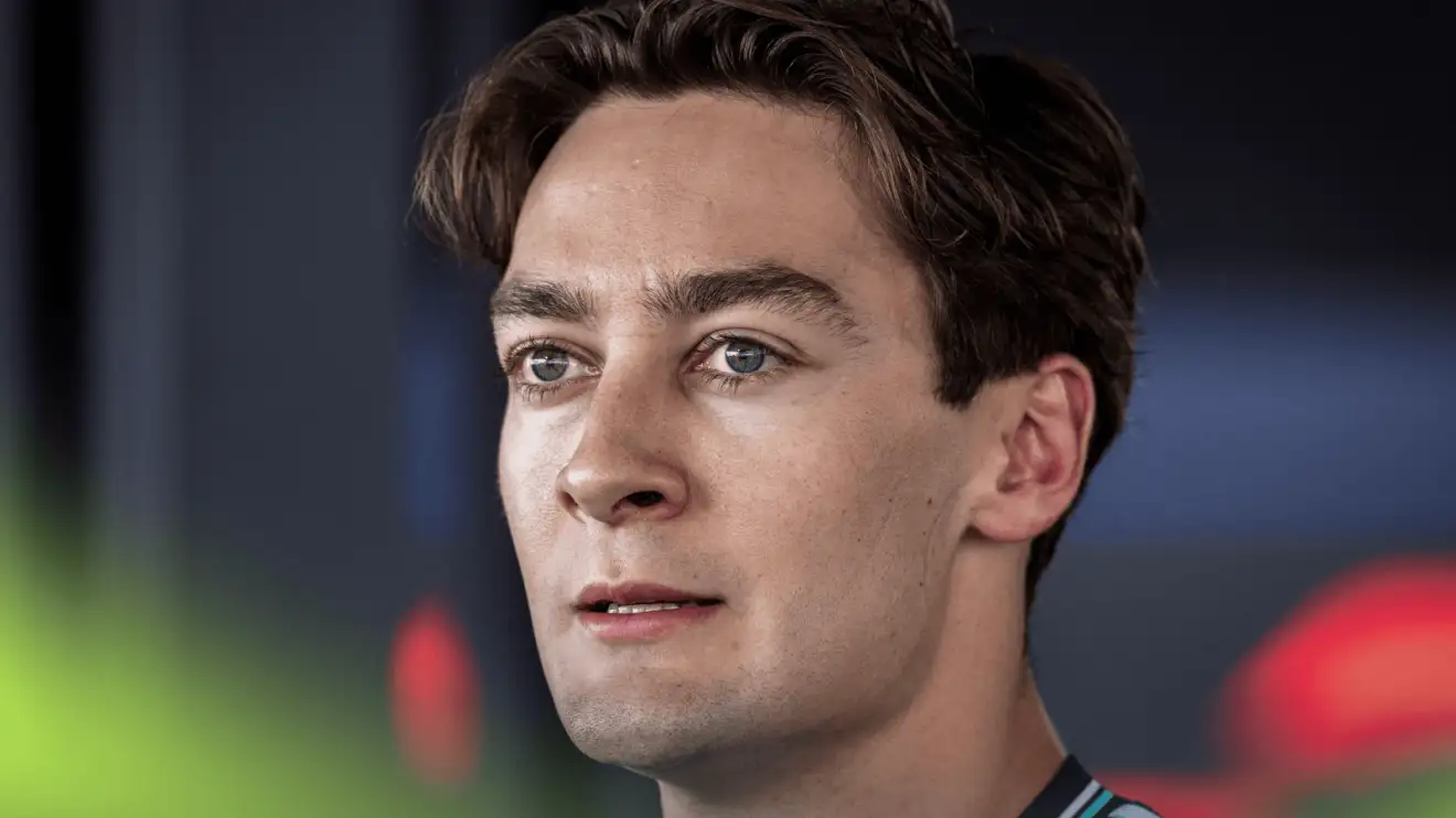 A close-up of George Russell mid speech as he faces the media