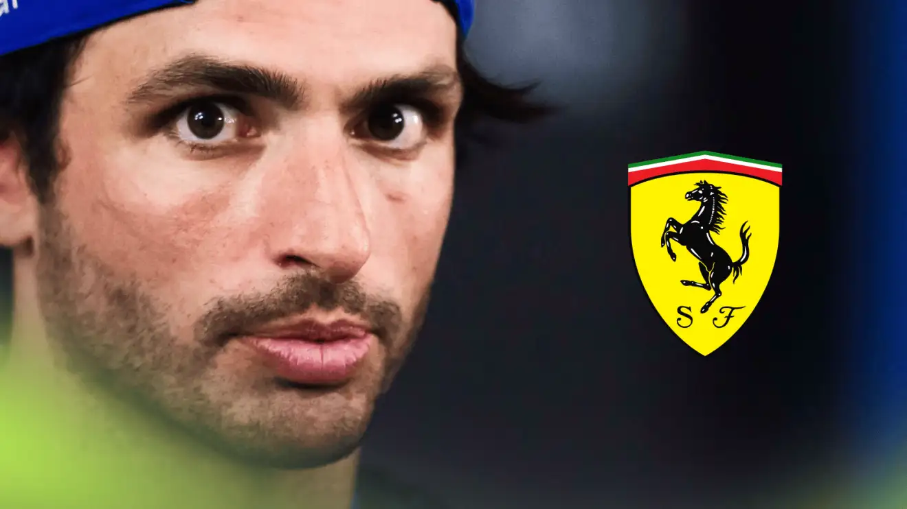 A close-up shot of Carlos Sainz eyeing the camera with a prominent Ferrari logo alongside him