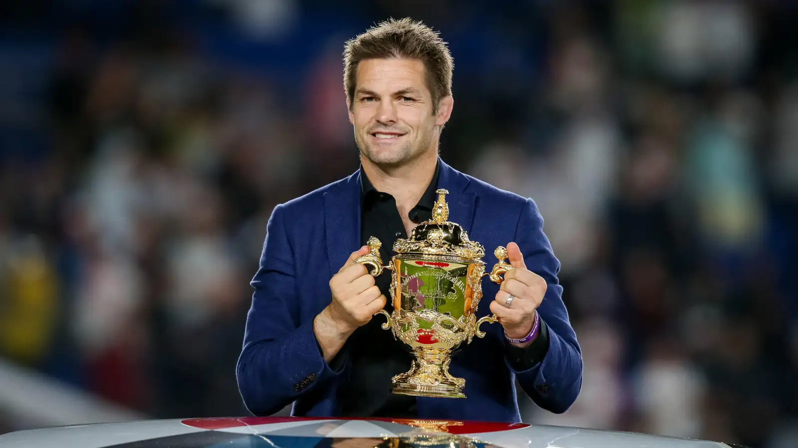 Former All Blacks captain Richie McCaw holds the Rugby World Cup trophy.