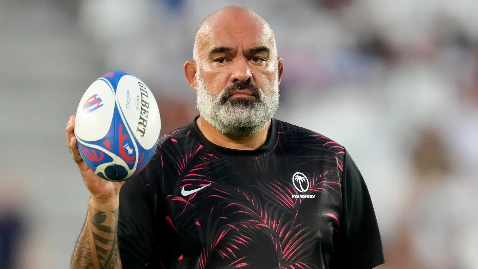 Fiji head coach Simon Raiwalui holding a ball at the Rugby World Cup.