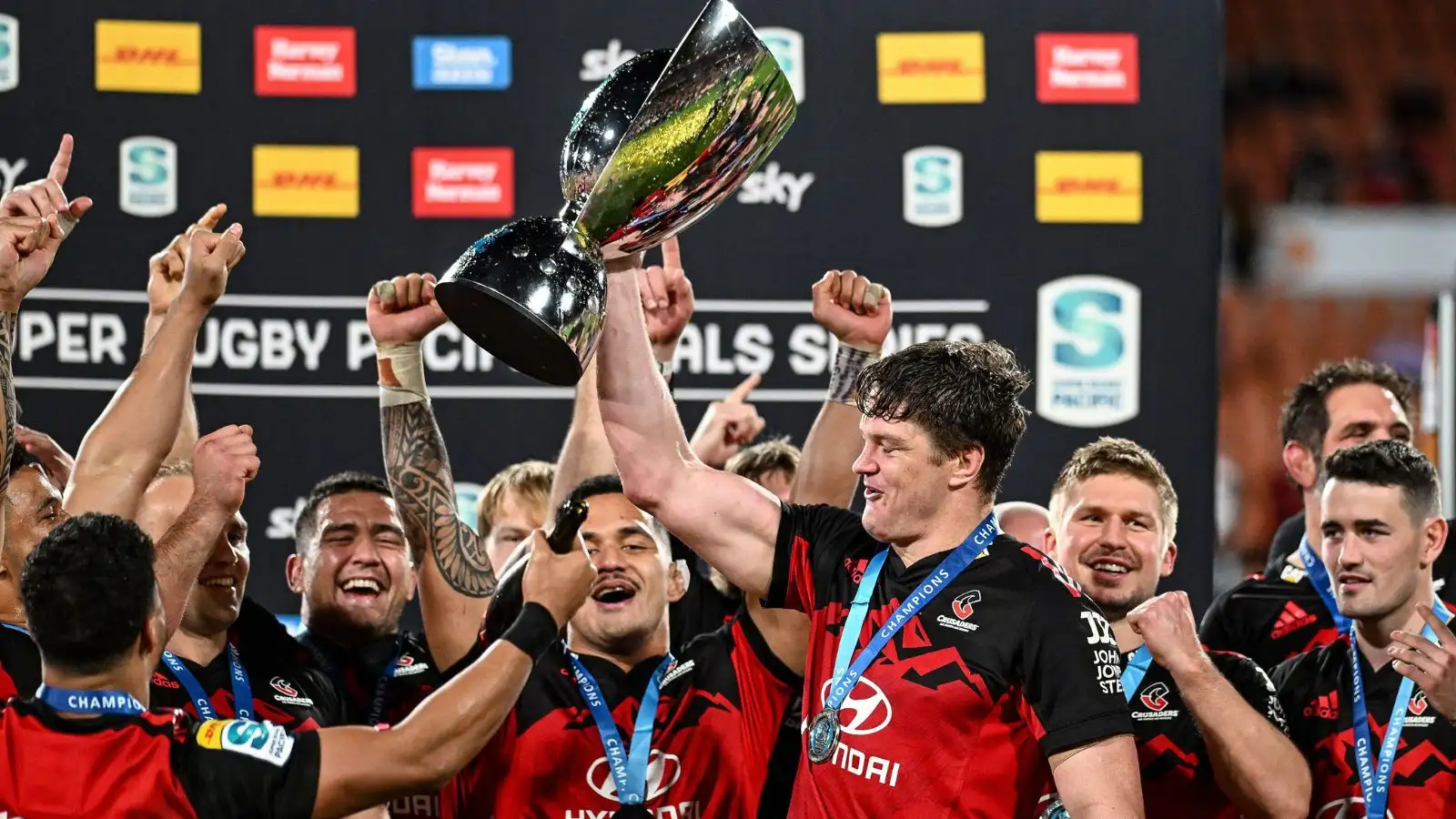 Crusaders captain Scott Barrett holds the trophy aloft as he celebrates with teammates after defeating the chiefs in the Super Rugby Pacific final in Hamilton, New Zealand, Saturday, June 24, 2023.