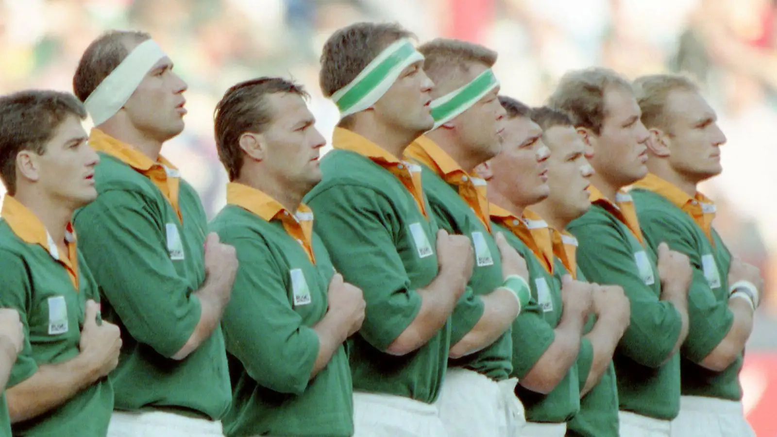 Joueurs sud-africains pendant l'hymne national avant le début de la finale de la Coupe du monde de rugby entre l'Afrique du Sud et la Nouvelle-Zélande à Ellis Park, Johannesburg en 1995 avec Hannes Strydom photographié aux côtés de Kobus Wiese.