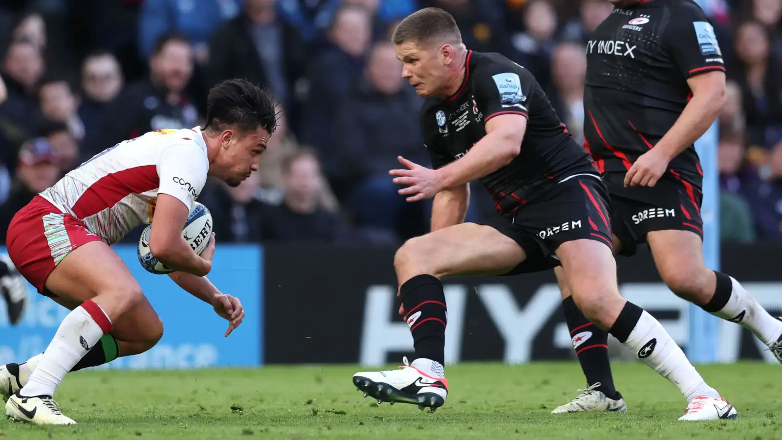 Owen Farrell tackling Marcus Smith during Saracens' clash with Harlequins in 2024.