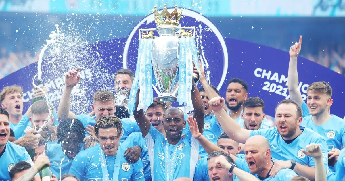 Fernandinho (C) of Manchester City lifts the trophy as he celebrates winning the Premier League with his teammates after beating Aston Villa during their English Premier League match in Manchester, Britain, May 22, 2022.