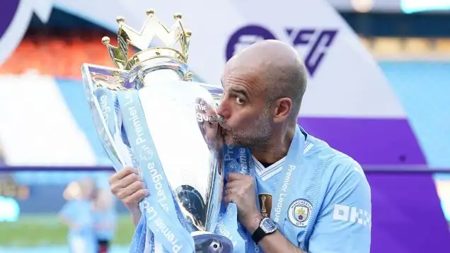 Manchester City manager Pep Guardiola kisses the Premier League trophy