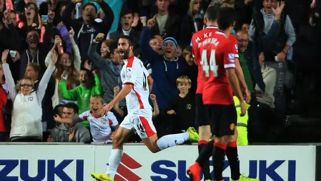 Will Grigg celebrates scoring against Manchester United.