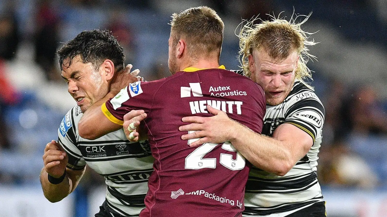 Andre Savelio and Hull FC team-mate Brad Fash tackle Huddersfield's Sam Hewitt. Picture by Dean Williams / Alamy Stock Photo.