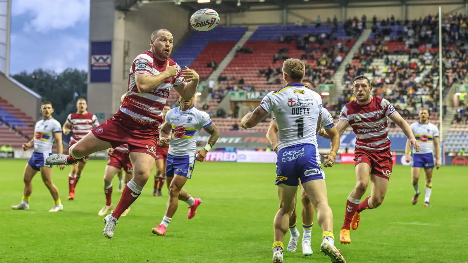 Wigan Warriors' Liam Marshall jumps for the ball against Warrington Wolves' Matt Dufty