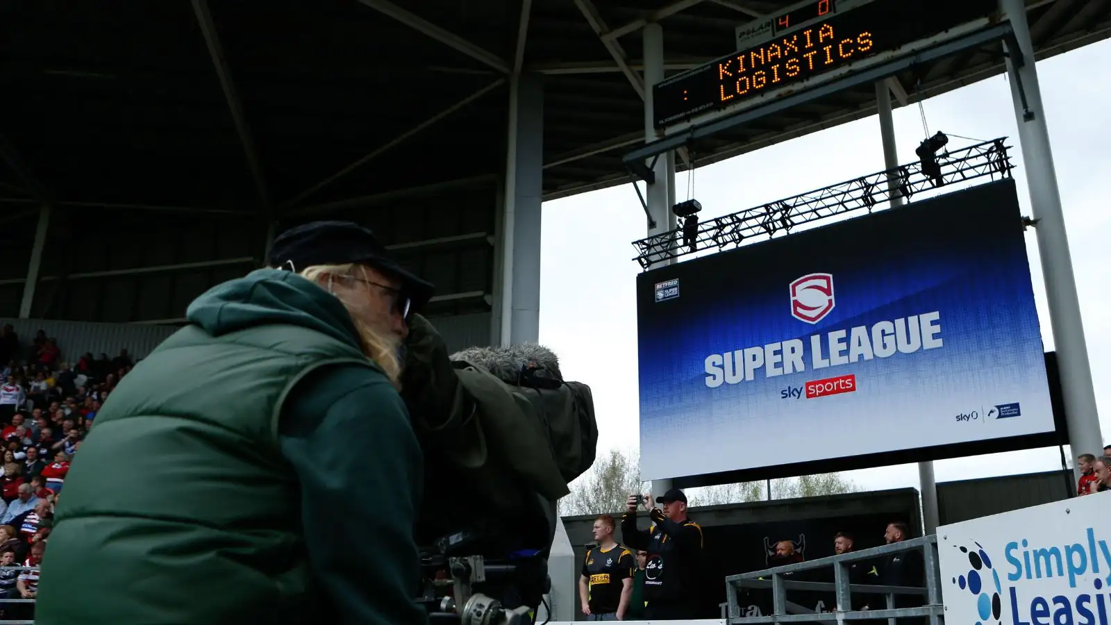 Cameraman pointing camera at Sky Sports Super League screen during a game