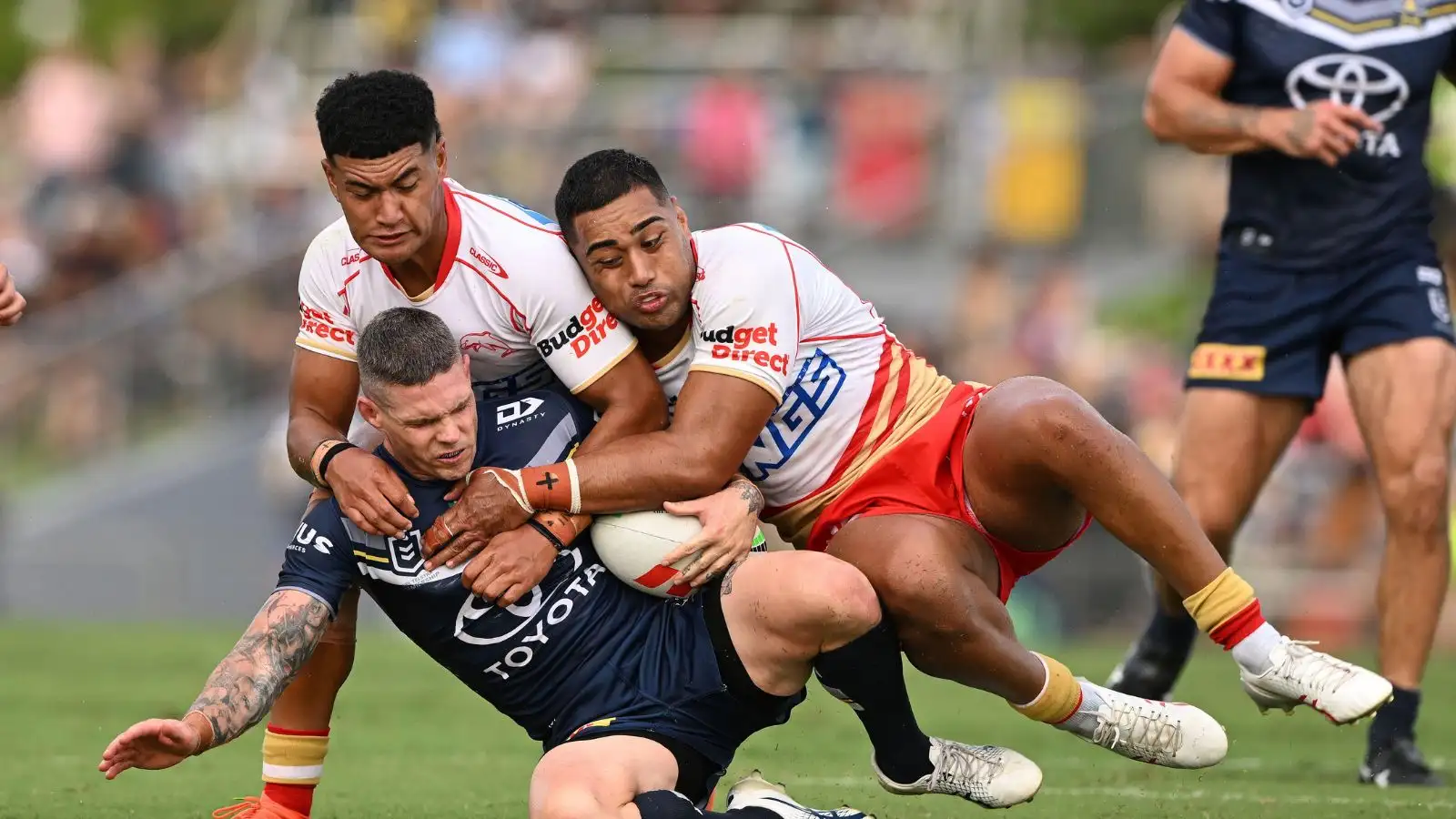 Ben Hampton of the Cowboys is tackled by Isaiya Katoa (left ) and Connelly Lemuelu of the Dolphins during the NRL Pre-Season Challenge match between the North Queensland Cowboys and the Dolphins. Photo by (AAP Image/Dave Hunt.