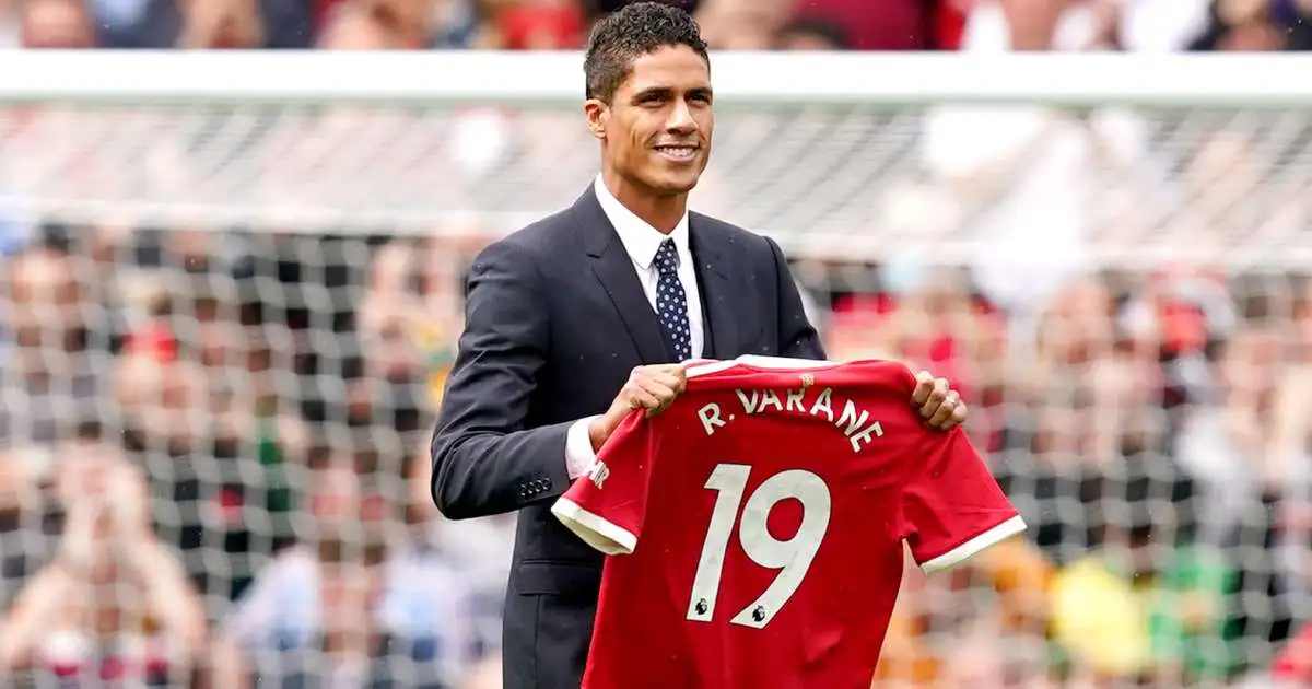 Raphael Varane holding his new Manchester United shirt at Old Trafford