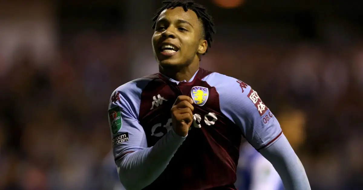 Cameron Archer holds the Aston Villa badge in celebration after scoring against Barrow
