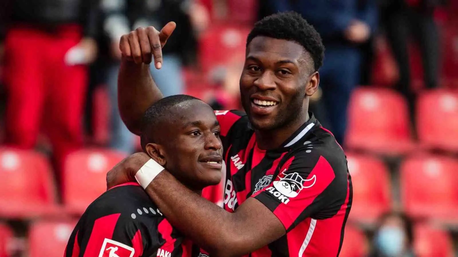 Timothy Fosu-Mensah pointing to Bayer Leverkusen teammate Moussa Diaby