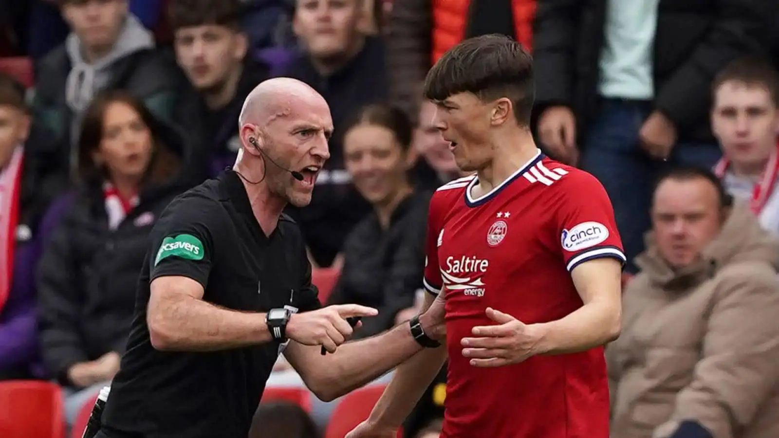 Calvin Ramsay - referee Bobby Madden pushes away Aberdeen defender after challenges on Celtic players during the cinch Premiership match at Pittodrie Stadium