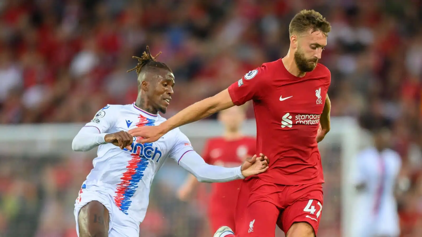 Nat Phillips of Liverpool holds off Wilfired Zaha during the Premier League match at Anfield