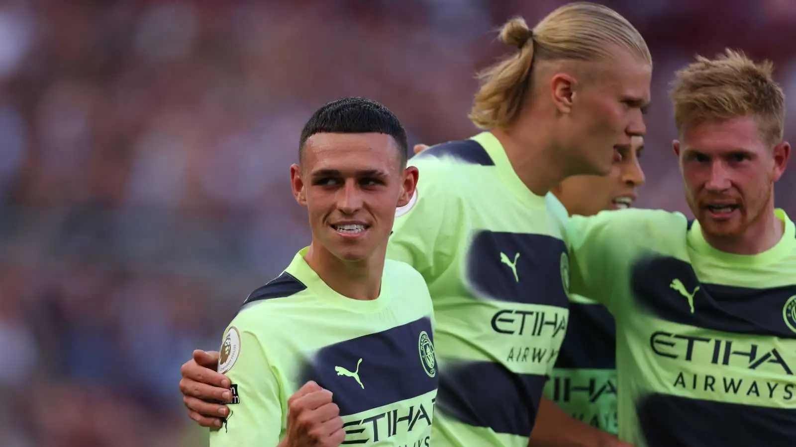 Phil Foden celebrating with Erling Haaland and Kevin De Bruyne