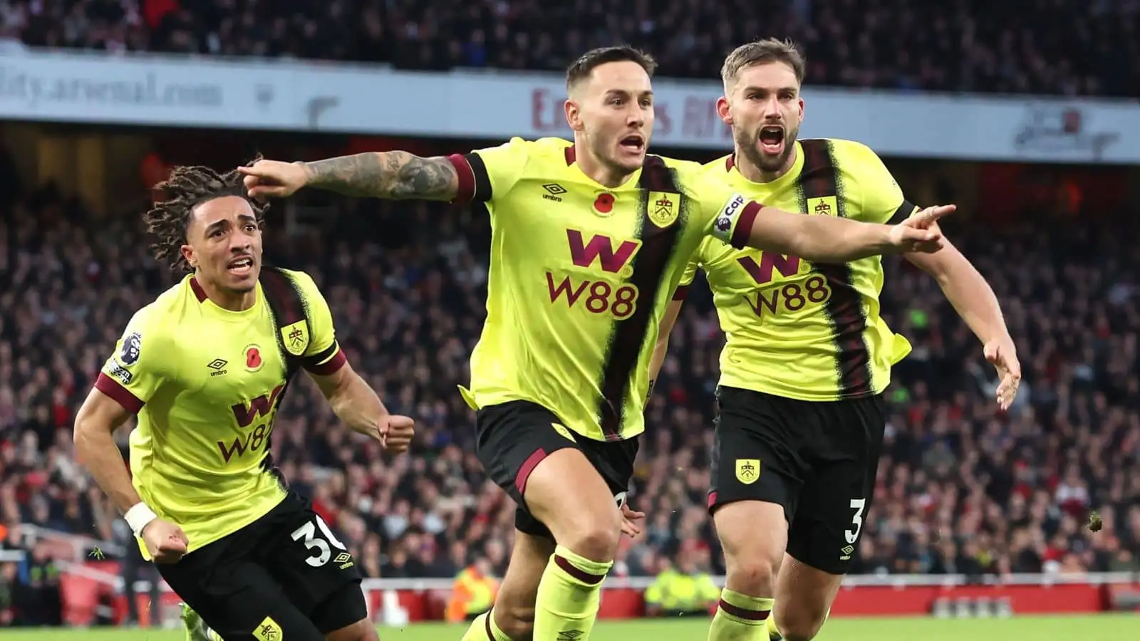 Luca Koleosho, Josh Brownhill and Charlie Taylor of Burnley celebrate a goal at Arsenal