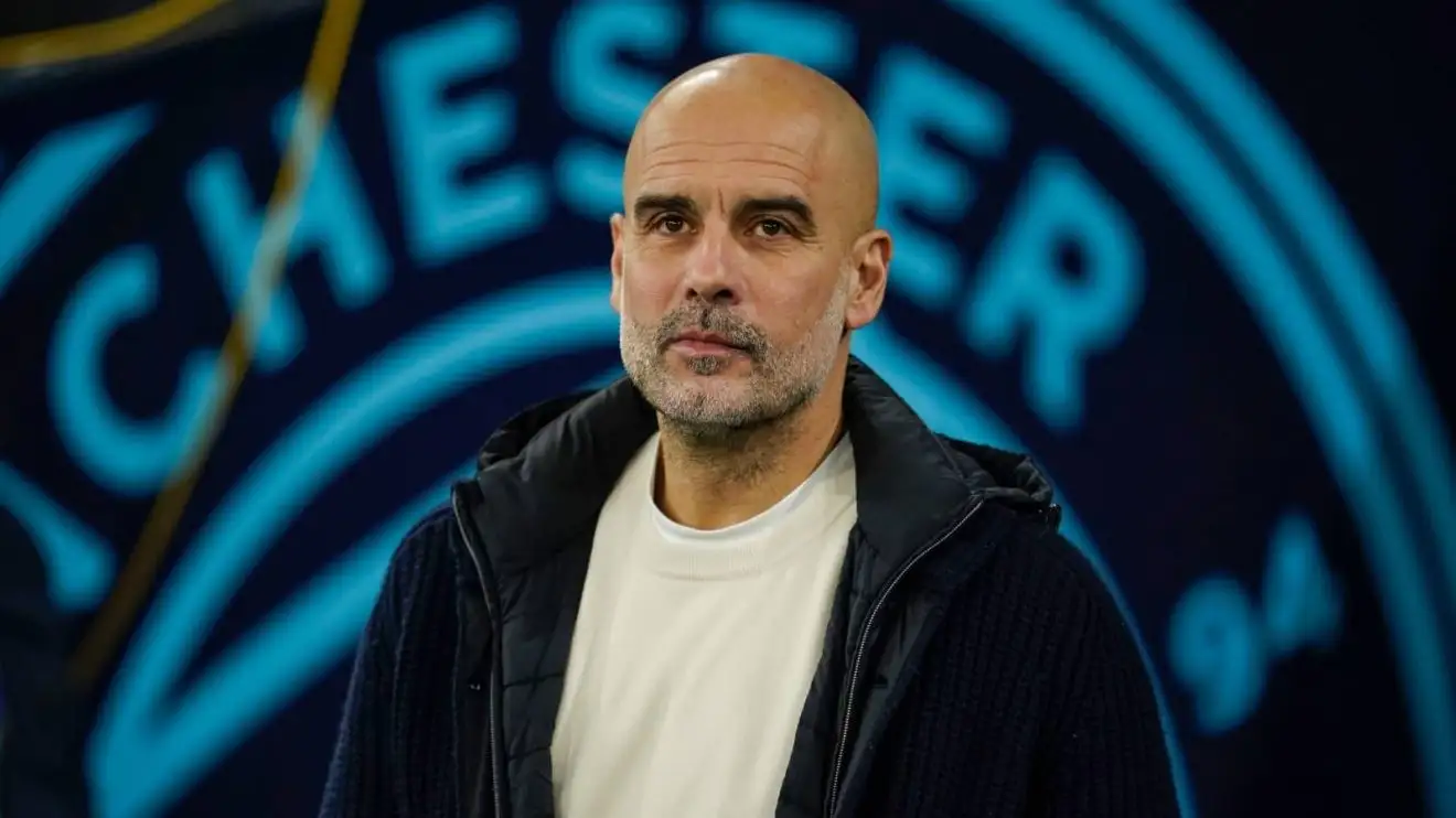 Pep Guardiola with Man City badge in background Pep Guardiola with Man City badge in background