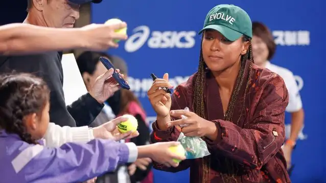 Pictured: Naomi Osaka signs an autograph in Tokyo.