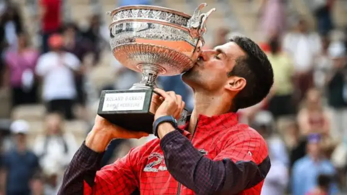 Novak Djokovic kisses the French Open title in 2023.