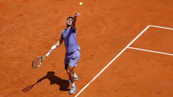 Carlos Alcaraz serves the ball